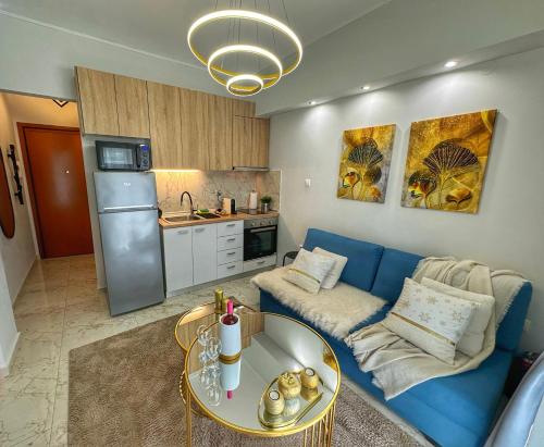 a living room with a blue couch and a table at Psimithefto Luxury Apartments in Thessaloniki