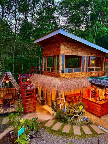 Tayabas的住宿－Juans Cabin，茅草屋顶和楼梯的小房子