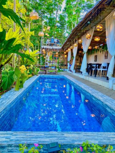 Tayabas的住宿－Juans Cabin，庭院里的一个蓝色海水游泳池
