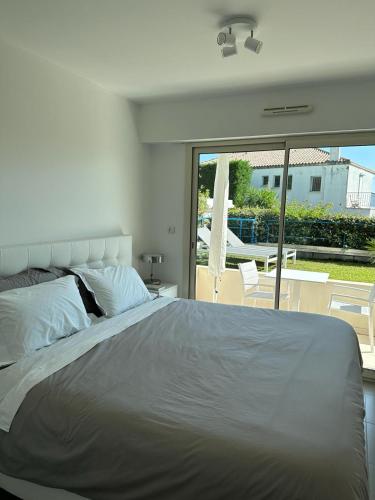 une chambre avec un grand lit blanc et un balcon dans l'établissement Résidence PARADIS BLEU - Appt 3P, à Cannes