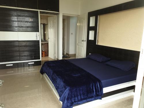 sypialnia z dużym łóżkiem i niebieskim kocem w obiekcie Palolem apartment w mieście Canacona