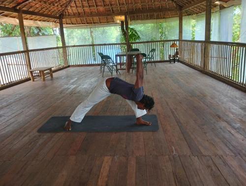 a man doing a yoga pose on a yoga mat at Ruban Yoga Eco Resort Palolem in Palolem