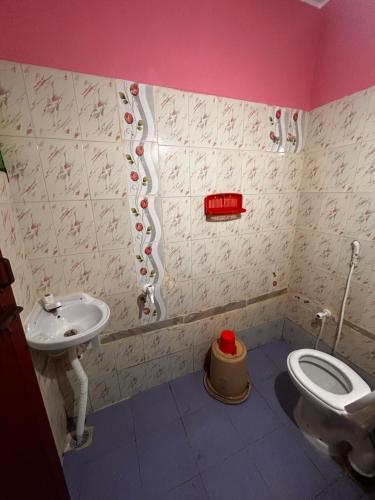 a bathroom with a toilet and a sink at Sri Thirumal Home Stay in Kumbakonam