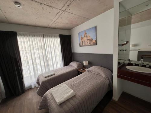 a hotel room with two beds and a sink at Departamentos en Gral Paz a pasos de clínicas in Cordoba