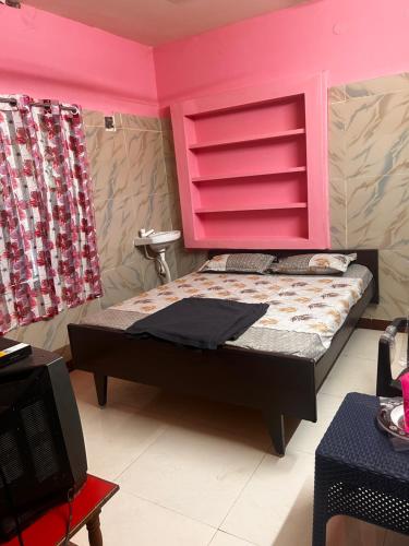 a bedroom with a bed with a pink headboard at Sri Thirumal Home Stay in Kumbakonam