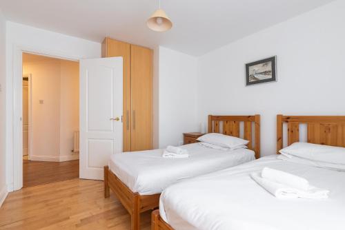 2 camas en una habitación con sábanas blancas en Ferncourt en Leopardstown