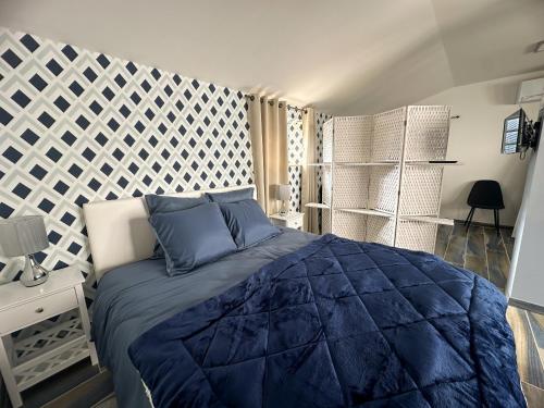 a bedroom with a large bed with blue pillows at Face Cité - Chambres D'Hôtes - Parking & Garage Gratuit - Wi-Fi Gratuit in Carcassonne