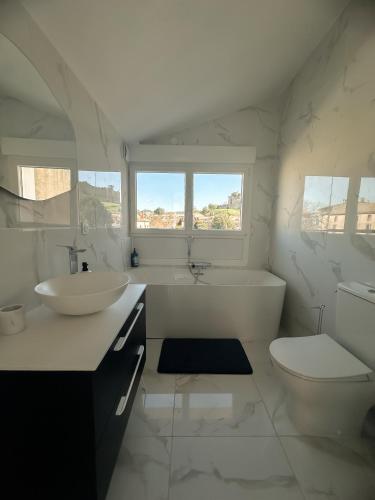une salle de bain blanche avec un lavabo et des toilettes dans l'établissement Face Cité - Chambres D'Hôtes - Parking & Garage Gratuit - Wi-Fi Gratuit, à Carcassonne