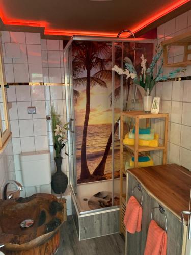 uma casa de banho com um chuveiro e um mural de palmeira em Best-Preis Ferienwohnung mit Netflix, Self-Check-In, eBike Ladestation im Fahrradraum, WLAN - direkt am Elberadweg im Herzen von Wittenberge em Wittenberge