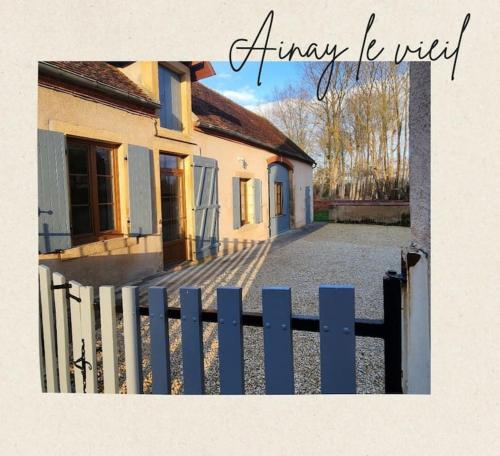 ein Haus mit einem Zaun davor in der Unterkunft Le Nid'Ainay Maison de Village entièrement rénovée in Ainay-le-Vieil