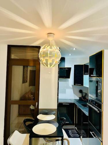a kitchen with two chairs and a chandelier at Appartement moderne vieille ville PARKING GRATUIT in Annecy