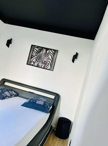 a bedroom with a bed with two pictures on the wall at Appartement moderne vieille ville PARKING GRATUIT in Annecy