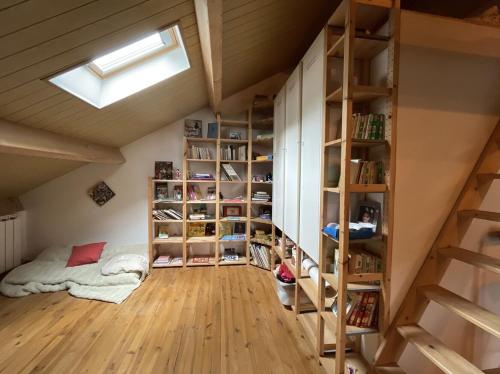 Cette chambre mansardée dispose d'étagères et d'un lit. dans l'établissement Gîte Maison Fougères gauche Saint-Prejet, à Saint-Préjet-dʼAllier