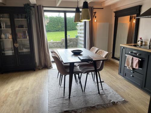 a dining room table and chairs in a kitchen at les gites du grand saule in Tardinghen