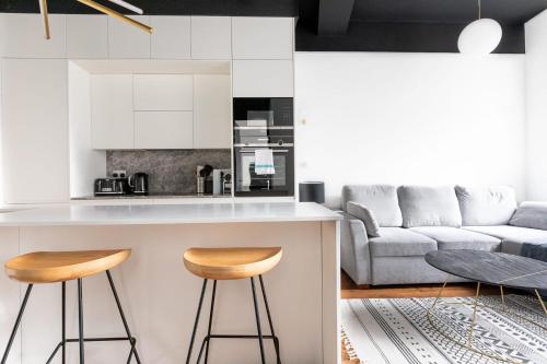 a kitchen and living room with a counter and stools at Luxury 1 Bed Apartment Covent Garden Holborn in London