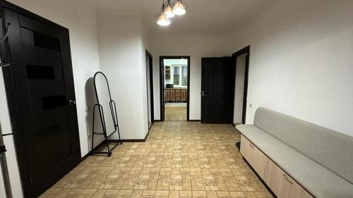Zimmer mit Flur mit Sofa und Tür in der Unterkunft Кунжут in Aqtöbe