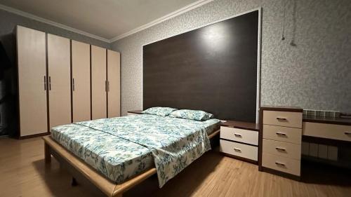 ein Schlafzimmer mit einem Bett, einer Kommode und einer Kommode in der Unterkunft Кунжут in Aqtöbe