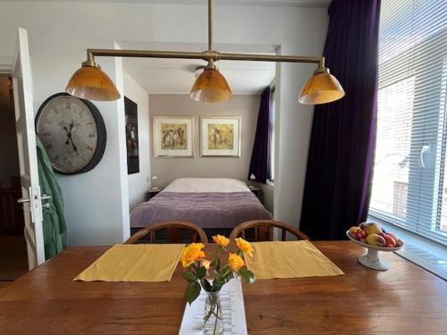 a room with a table and a bed with a clock at PetitGrandeur in Maastricht