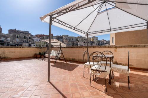 a patio with two chairs and an umbrella on a roof at Terrazze San Martino in Matera