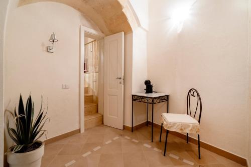 a hallway with a table and a chair and a door at Terrazze San Martino in Matera
