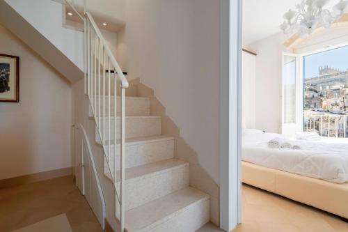 a staircase in a bedroom with a bed and a window at Terrazze San Martino in Matera