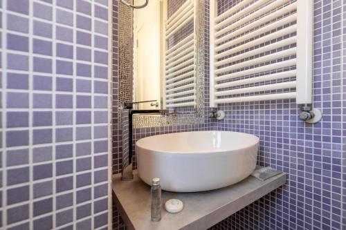 a white sink in a blue tiled bathroom at Terrazze San Martino in Matera