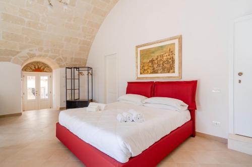 a bedroom with a red bed with towels on it at Terrazze San Martino in Matera