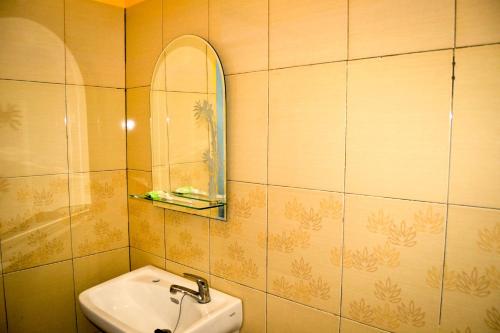 uma casa de banho com um lavatório e um espelho em Hotel Ledetadu em Kupang