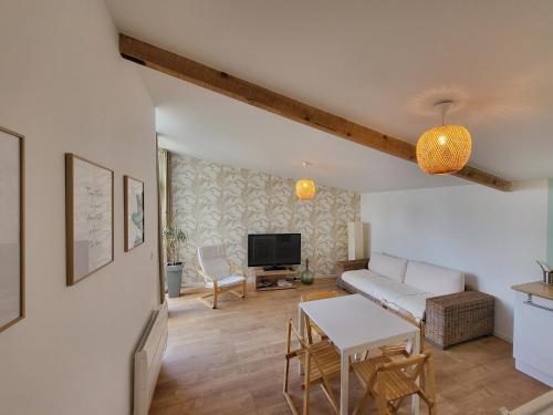 sala de estar con sofá y mesa en Gite cosy et spacieux, en Étoile-sur-Rhône