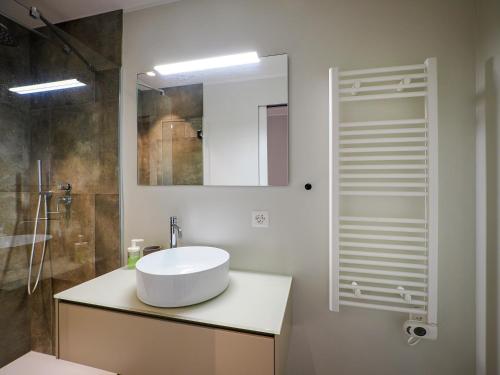 Baño blanco con lavabo y espejo en Appartamento Festival 8 en Muralto