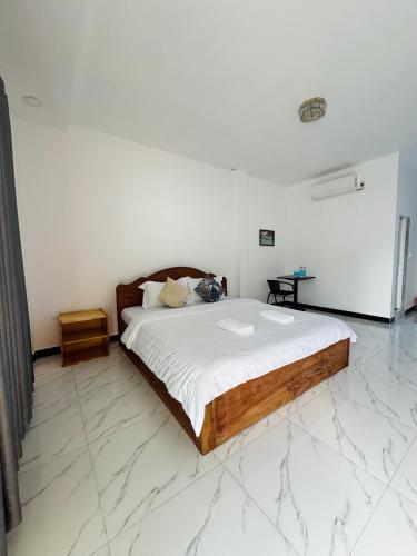 a bedroom with a large bed with a marble floor at BM guest house in Phnom Penh