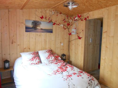 Un dormitorio con una cama con flores rojas. en ESCALE AU FOND DU JARDIN, en Agen