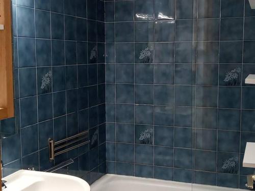 Baño de azulejos azules con aseo y lavamanos en Appartement Saint-Jean-d'Aulps, 1 pièce, 6 personnes - FR-1-573-71, en Saint-Jean-dʼAulps