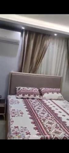 a bed in a room with a curtain and a bed frame at المريوطيه فيصل in Cairo