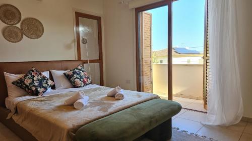 sypialnia z łóżkiem i dużym oknem w obiekcie STAY Tranquility Cove w Larnace
