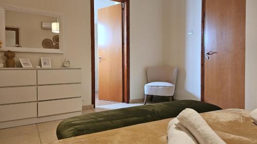 sypialnia z łóżkiem, komodą i krzesłem w obiekcie STAY Tranquility Cove w Larnace