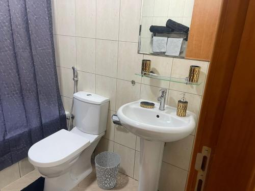 a bathroom with a toilet and a sink at A chilled place JVC in Dubai