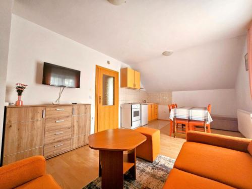 a living room with a table and a kitchen at Apartman M. Rados in Kupres