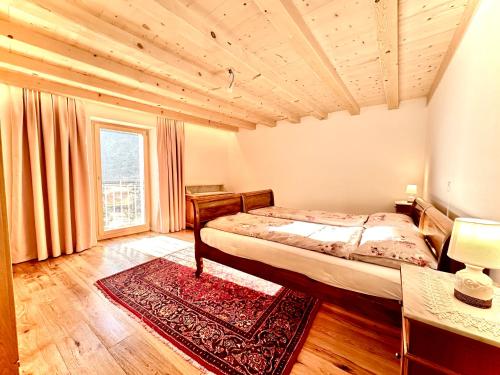 een slaapkamer met een bed en een groot raam bij Cà Laura in Brusio