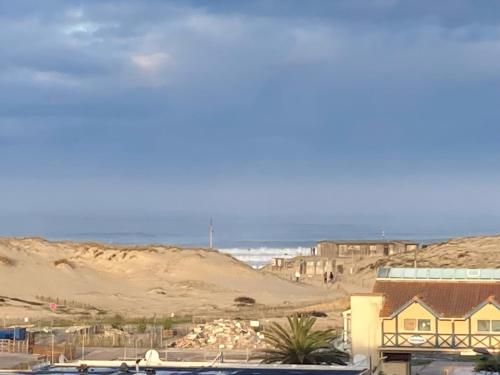 a view of a beach with a house and the ocean at Bel appartement climatisé refait à neuf 100 m de l'océan et toutes commodités 3 e étage sans ascenseur in Seignosse