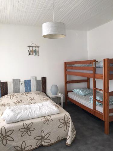 une chambre avec deux lits et un lit superposé dans l'établissement Charmante Maison, terrasse vue mer, à Les Sables-dʼOlonne
