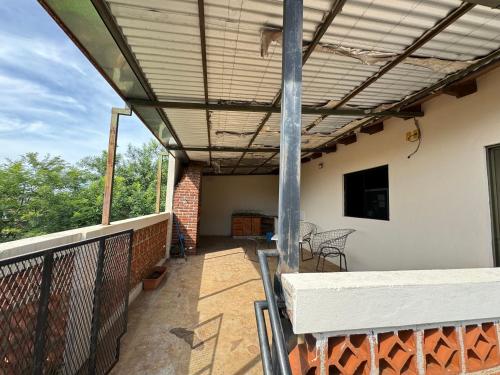 une terrasse avec un auvent, une table et des chaises dans l'établissement Departamento ganesha, à Encarnación