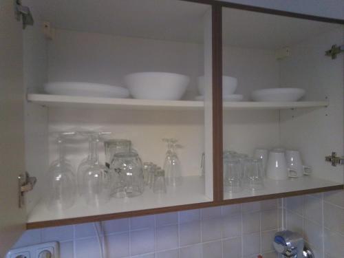 einem Küchenschrank mit Gläsern, Schalen und Tellern in der Unterkunft Benjamin 1 in Plauen