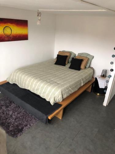 une chambre avec un grand lit dans une pièce dans l'établissement Maison de ville, à Le Petit-Quevilly