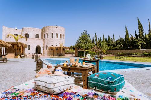 a patio with a table and a swimming pool at RIAD YANITRI Piscine chauffée in Essaouira