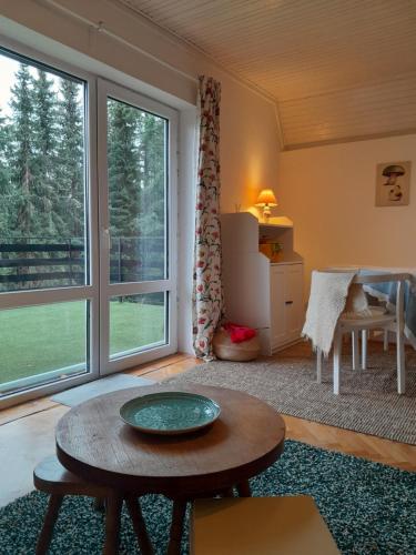 un soggiorno con un tavolo e una grande finestra di Pine tree cottage a Zlatibor