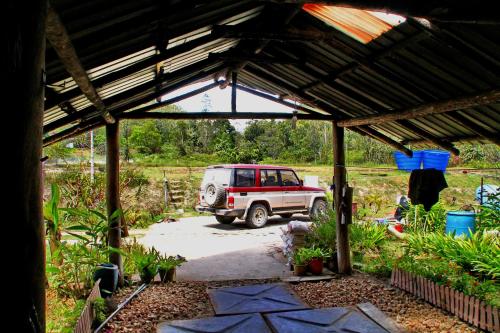 a car parked in a garage with a roof at Labang Guesthouse Bario in Bario