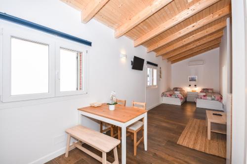 cocina y sala de estar con mesa de madera y sillas en Acogedora Suite con entrada independiente en Masnou