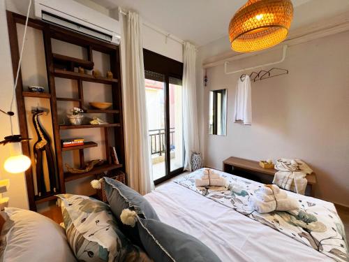 a bedroom with a bed and a window at Casa Portokali Chalkidiki - Modern Comfort with Authentic Greek Charm in Nea Potidaea