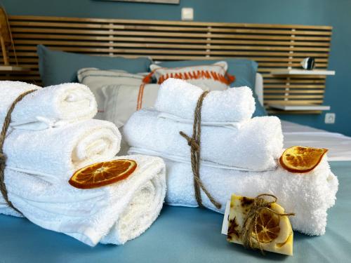 a pile of towels sitting on top of a bed at Casa Portokali Chalkidiki - Modern Comfort with Authentic Greek Charm in Nea Potidaea
